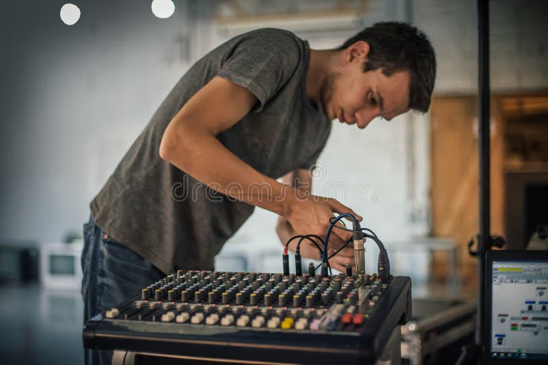 Detrás de la escena. técnico de sonido ingeniero eléctrico ajustando elementos de sonido imagenes de archivo