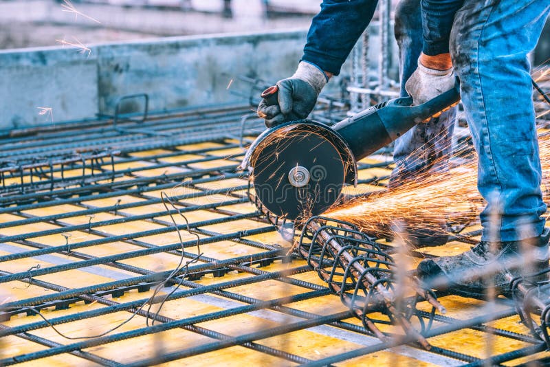 Industrial details with worker cutting steel bars and reinforced steel with angle grinder. Filtered image. Industrial details with worker cutting steel bars and reinforced steel with angle grinder. Filtered image