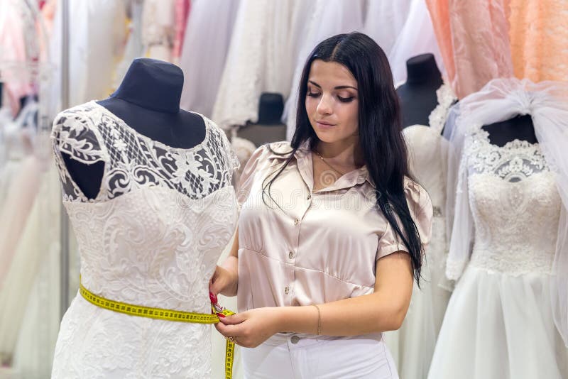 dettagli di misurazione del venditore della donna del vestito da sposa fotografie stock dettagli di misurazione del venditore della donna del vestito da sposa fotografie stock