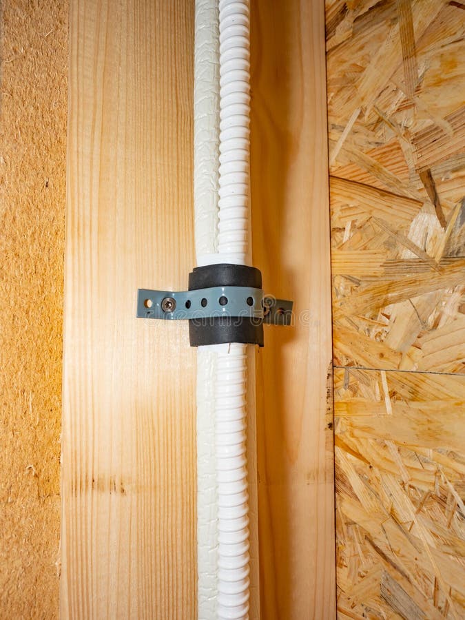 Detail of a flexible protective hose with electrical wiring in a wooden wall. Wooden house electric distribution. Detail of a flexible protective hose with electrical wiring in a wooden wall. Wooden house electric distribution