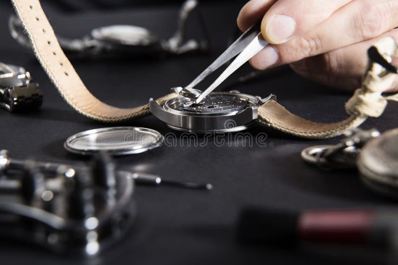 Dettaglio del lavoro di un orologiaio che sostituisce una batteria fotografia stock libera da diritti Dettaglio del lavoro di un orologiaio che sostituisce una batteria fotografia stock libera da diritti
