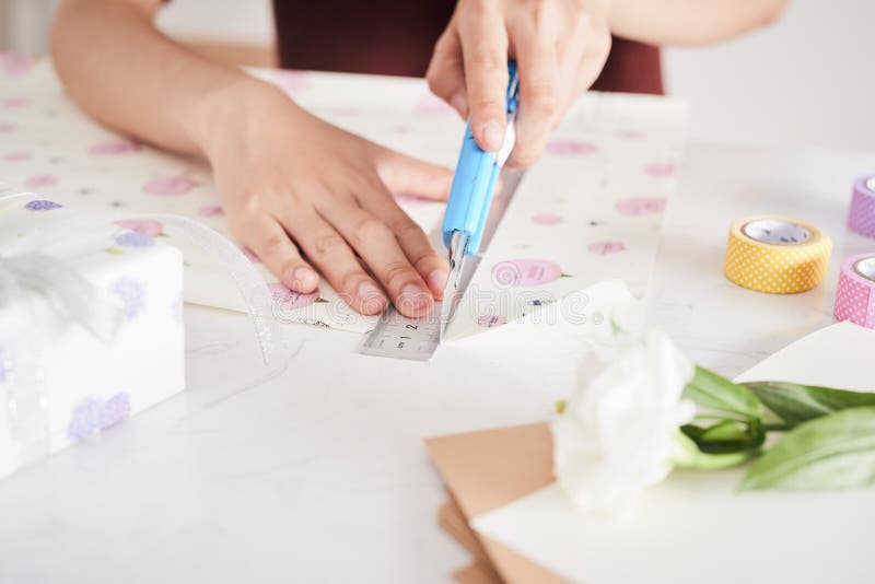 Dettaglio delle mani della donna che imballano alcuni presente con la carta del regalo immagini stock Dettaglio delle mani della donna che imballano alcuni presente con la carta del regalo immagini stock