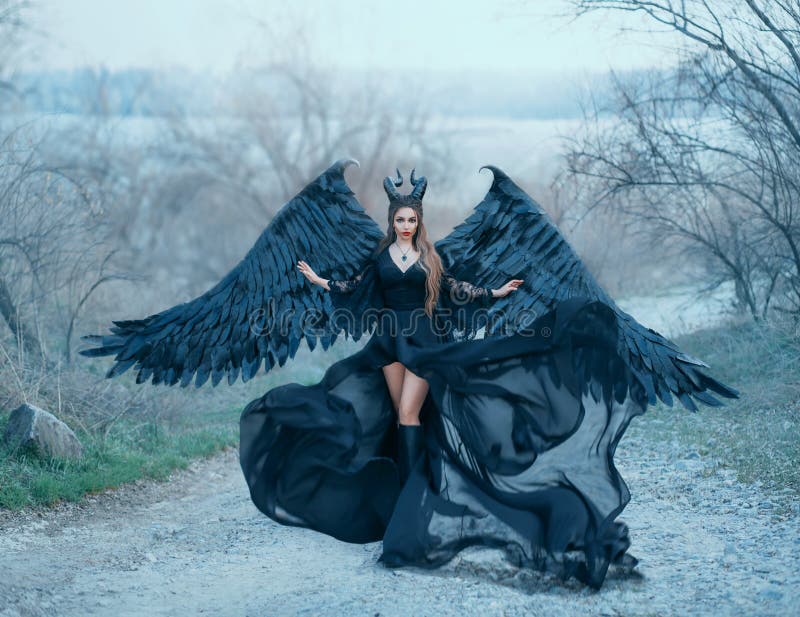 A deusa escura lindo de encantamento controla o vento, a bainha das ondas do fluxo de ar e o trem longo do vestido preto leve com imagens de stock A deusa escura lindo de encantamento controla o vento, a bainha das ondas do fluxo de ar e o trem longo do vestido preto leve com imagens de stock