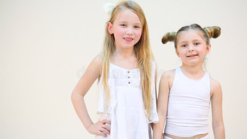 Deux adorables petites filles tenant la main isolée banque de vidéos