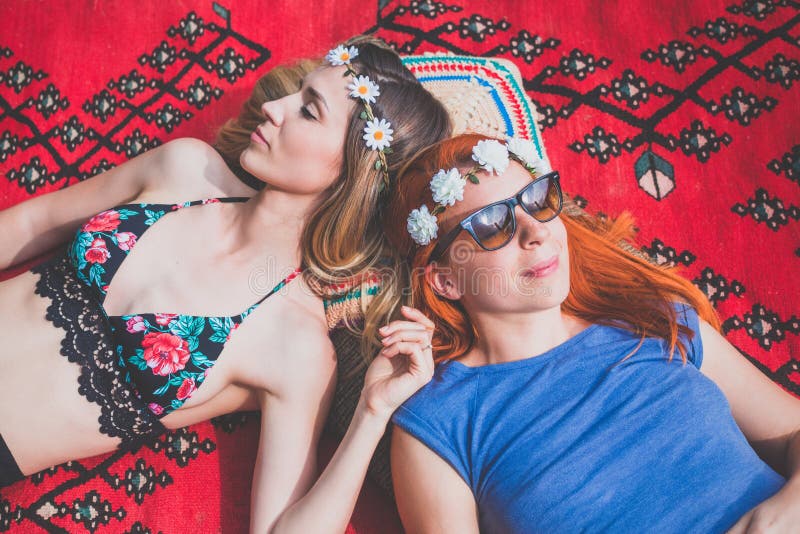 Deux amies hippies se reposant sur la couverture dehors photographie stock libre de droits Deux amies hippies se reposant sur la couverture dehors photographie stock libre de droits