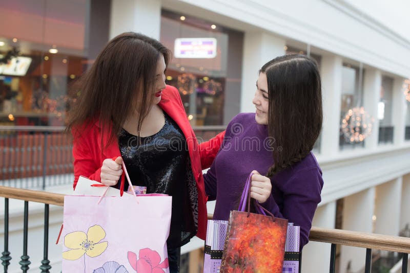 Deux amis heureux faisant des emplettes dans le mail, regard à leur achat