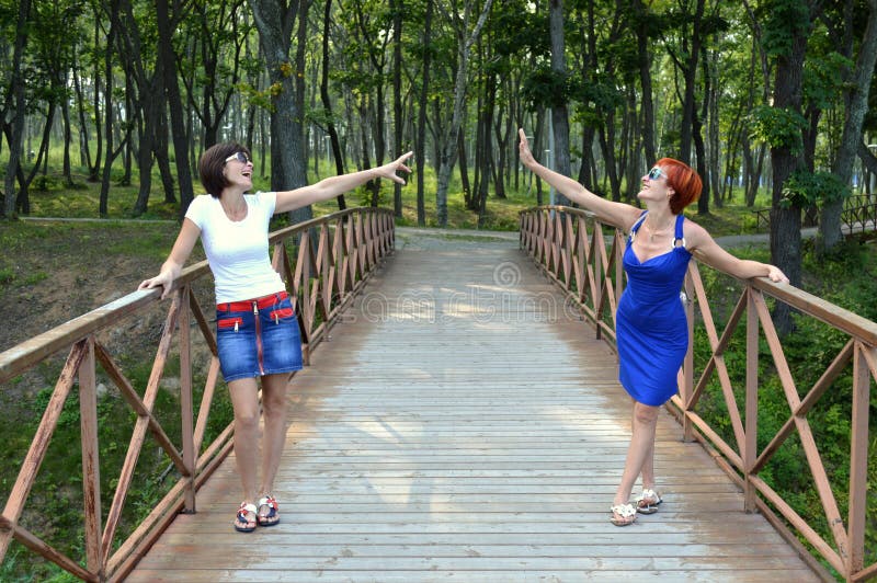 Deux belles soeurs allongeant les mains entre eux et riant sincèrement image stock