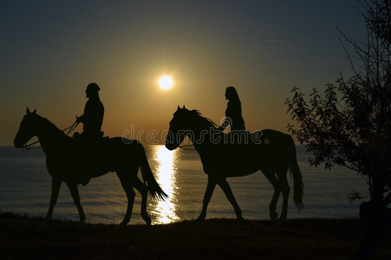 Deux cavaliers montant pendant le coucher du soleil sur le bord de la mer photographie stock Deux cavaliers montant pendant le coucher du soleil sur le bord de la mer photographie stock
