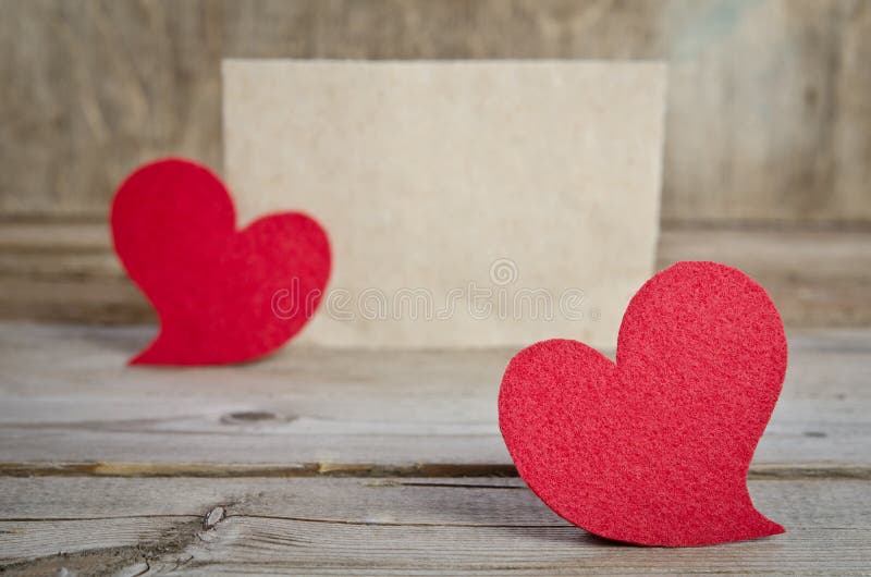 Deux coeurs rouges de tissu sur un conseil en bois photo libre de droits Deux coeurs rouges de tissu sur un conseil en bois photo libre de droits