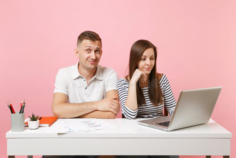 Deux collègues de sourire d'homme de femme d'affaires reposent le travail au bureau blanc avec l'ordinateur portable contemporain photo libre de droits Deux collègues de sourire d'homme de femme d'affaires reposent le travail au bureau blanc avec l'ordinateur portable contemporain photo libre de droits