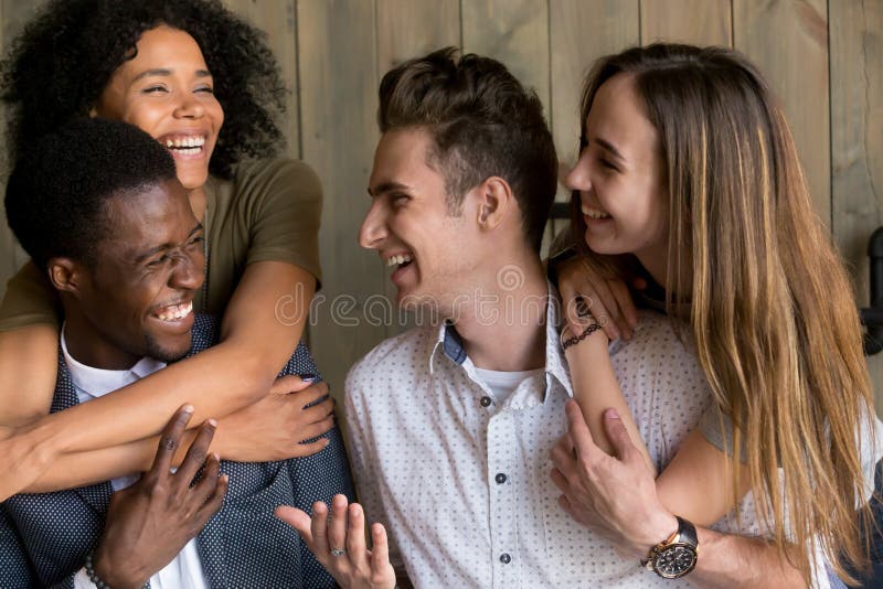 Two happy african and caucasian couples embracing bonding having fun together, young cheerful diverse men and women in love hugging smiling laughing, multiracial friendship, racial diversity concept. Two happy african and caucasian couples embracing bonding having fun together, young cheerful diverse men and women in love hugging smiling laughing, multiracial friendship, racial diversity concept