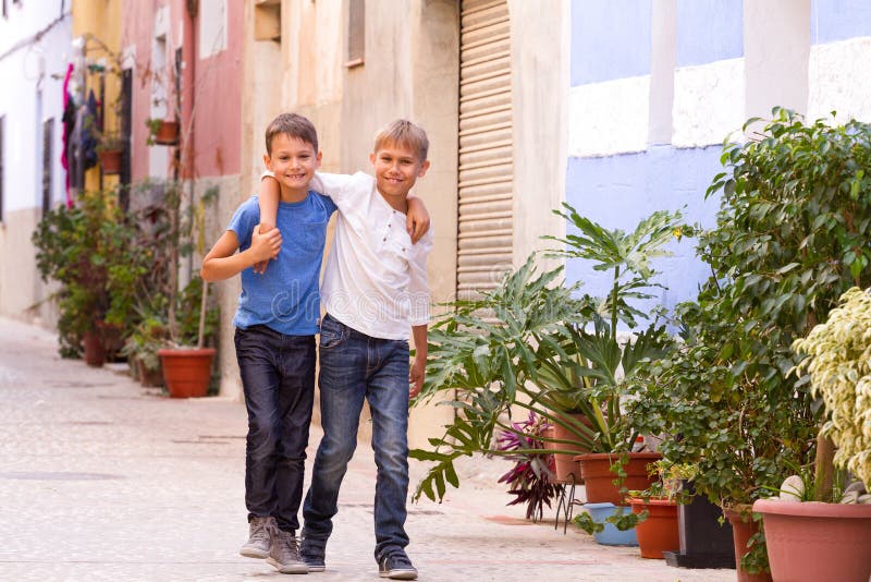 Deux enfants heureux dehors dans la ville européenne de rue le jour d'été photo stock Deux enfants heureux dehors dans la ville européenne de rue le jour d'été photo stock
