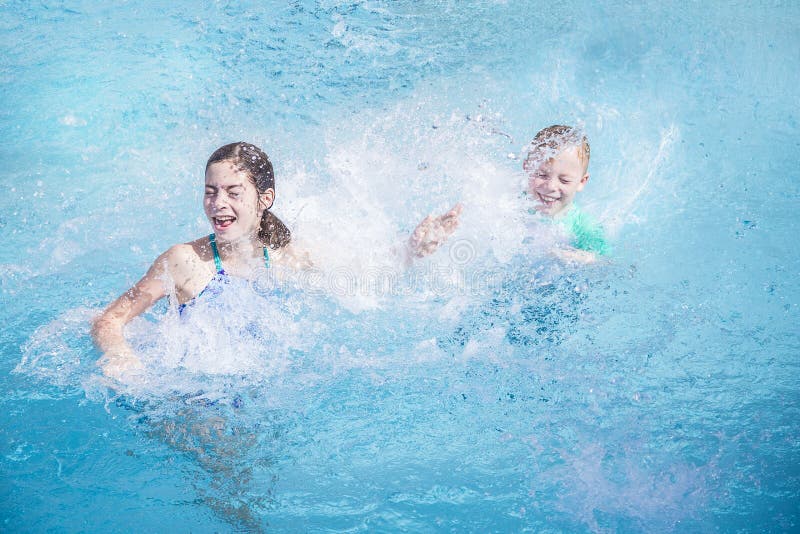 Deux enfants s'éclaboussant dans la piscine tandis que des vacances photo stock Deux enfants s'éclaboussant dans la piscine tandis que des vacances photo stock
