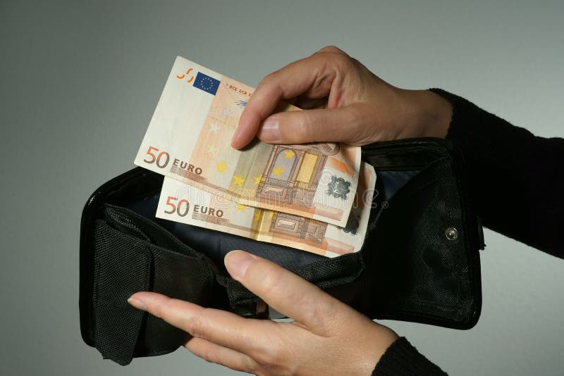 Close-up on female hands withdrawing the two last 50 Euro banknotes out of an empty black wallet. Grey background. Close-up on female hands withdrawing the two last 50 Euro banknotes out of an empty black wallet. Grey background.