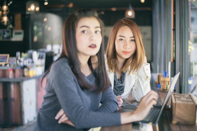 Deux femmes asiatiques d'affaires employant le fonctionnement et la discussion o de carnet images libres de droits Deux femmes asiatiques d'affaires employant le fonctionnement et la discussion o de carnet images libres de droits