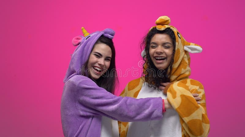Deux femmes dans des pyjamas de licorne et de girafe riant et étreignant, amitié clips vidéos