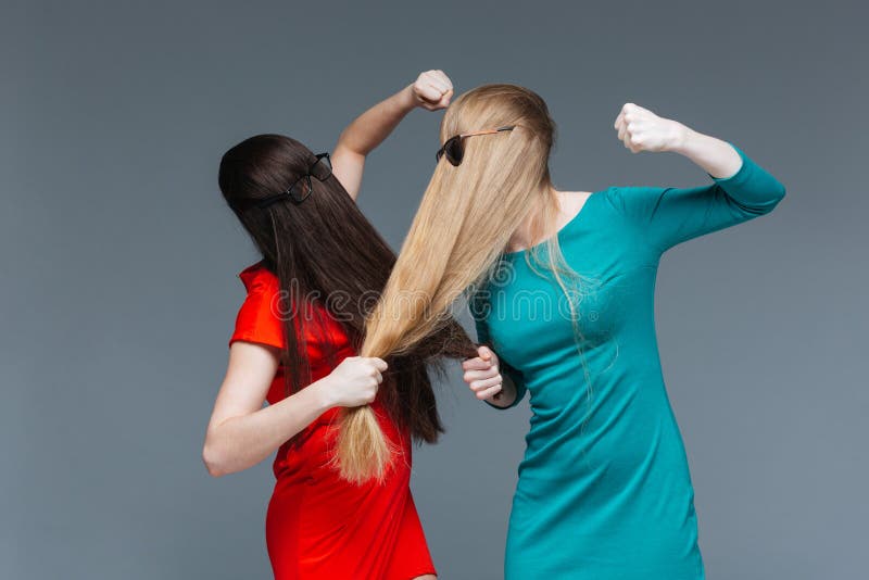 Deux femmes fâchées ont couvert le visage de longs cheveux et de combat photos stock Deux femmes fâchées ont couvert le visage de longs cheveux et de combat photos stock
