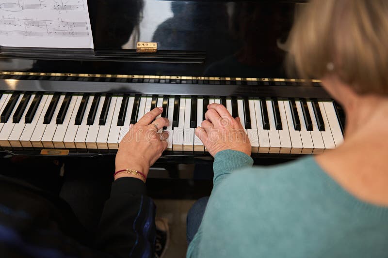 Deux femmes matures à la maison jouent ensemble du piano et chantent. leçons de piano vocale et musicale pour adultes. photo stock