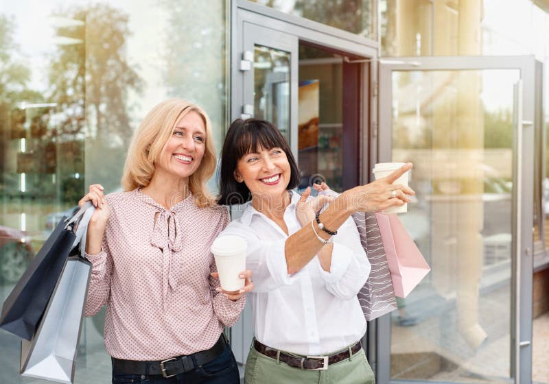Deux femmes adultes qui s'amusent en faisant du shopping et en buvant du café photos libres de droits