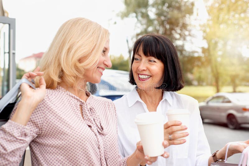 Deux femmes adultes qui s'amusent en faisant du shopping et en buvant du café images libres de droits
