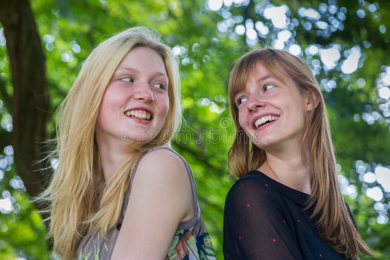 Deux filles aux cheveux longs riant entre eux photo libre de droits Deux filles aux cheveux longs riant entre eux photo libre de droits