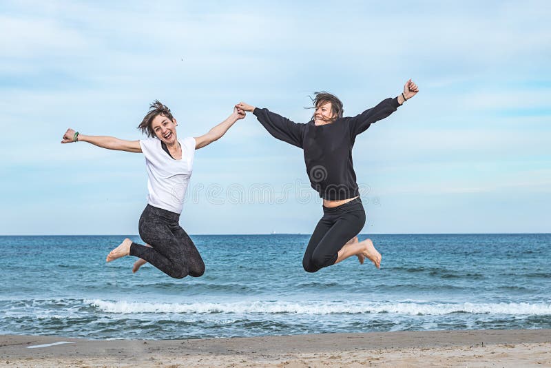 Deux filles branchant sur la plage image stock Deux filles branchant sur la plage image stock