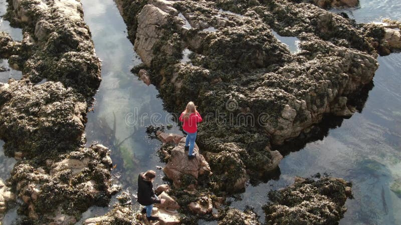 Deux filles dans la montée de l'Irlande au-dessus du côtier rocheux de Malin Head