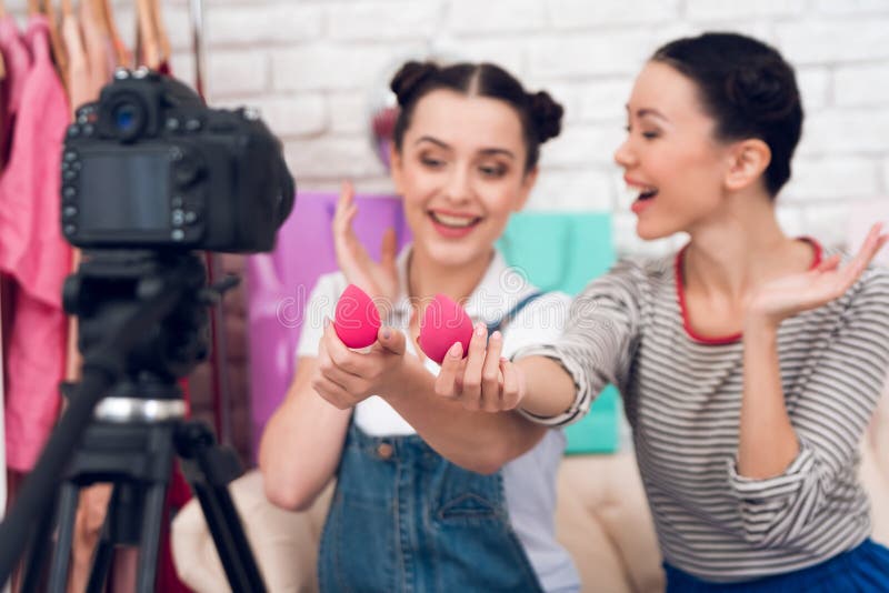 Deux filles de blogger de mode supportent les éponges rouges à l'appareil-photo photos stock Deux filles de blogger de mode supportent les éponges rouges à l'appareil-photo photos stock