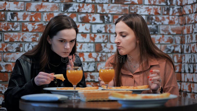 Two cheerful girls in a cafe having dinner. Two cheerful girls in a cafe having dinner