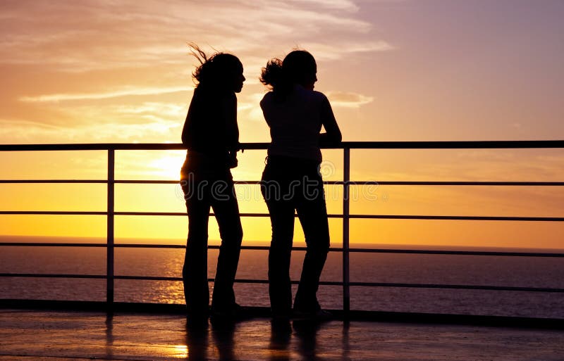 Two girls black silhouette and red sunset on a ferry. Two girls black silhouette and red sunset on a ferry