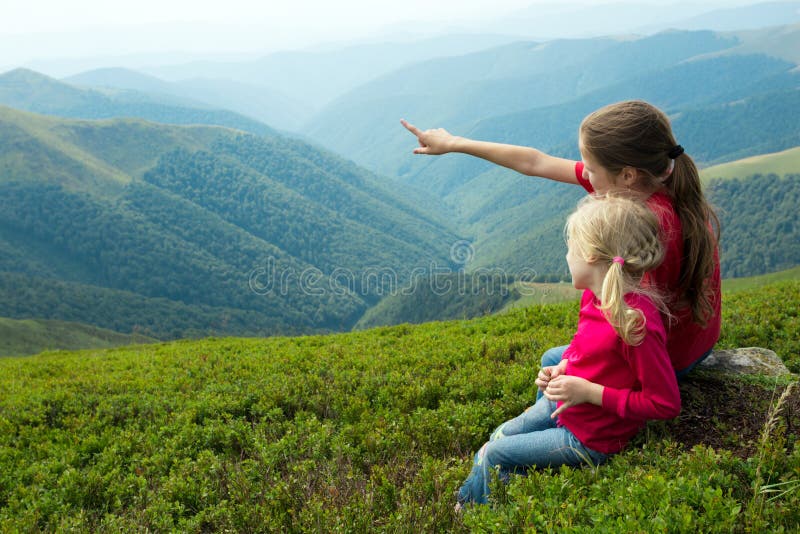 Deux filles regardant les montagnes photographie stock Deux filles regardant les montagnes photographie stock