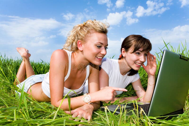 Deux filles riant et regardant l'ordinateur portable photo stock Deux filles riant et regardant l'ordinateur portable photo stock