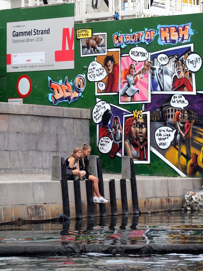 Deux filles sur une banque avec le graffiti à Copenhague images libres de droits Deux filles sur une banque avec le graffiti à Copenhague images libres de droits