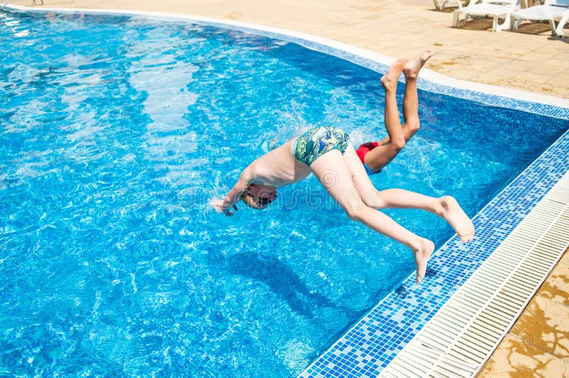 Deux garçons sautant dans la piscine images libres de droits Deux garçons sautant dans la piscine images libres de droits