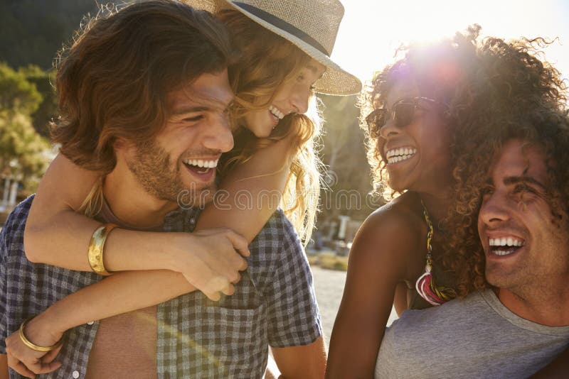 Two young couples piggybacking at the beach, Ibiza, Spain. Two young couples piggybacking at the beach, Ibiza, Spain