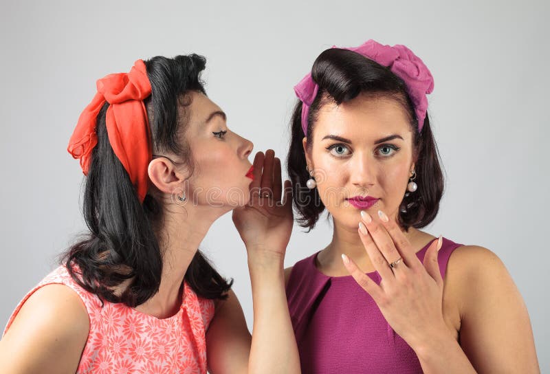 Deux jeunes femmes chuchotant le bavardage image stock Deux jeunes femmes chuchotant le bavardage image stock
