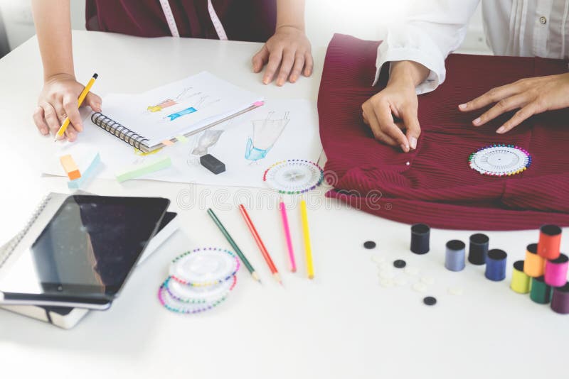 Deux jeunes femmes travaillant comme couturiers et sketche de dessin photos stock