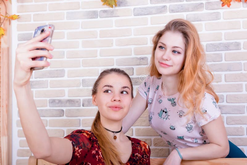 Deux jeunes filles de charme prennent un selfie au téléphone image stock