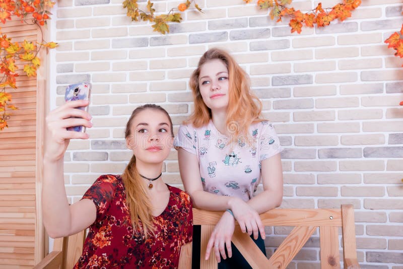 Deux jeunes filles de charme prennent un selfie au téléphone photos stock