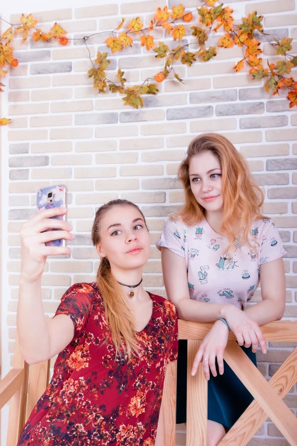 Deux jeunes filles de charme prennent un selfie au téléphone images stock