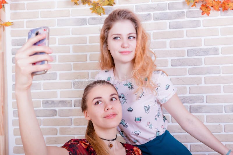 Deux jeunes filles de charme prennent un selfie au téléphone photographie stock libre de droits