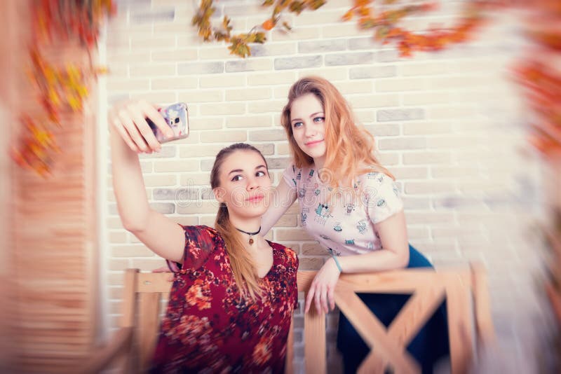 Deux jeunes filles de charme prennent un selfie au téléphone images libres de droits