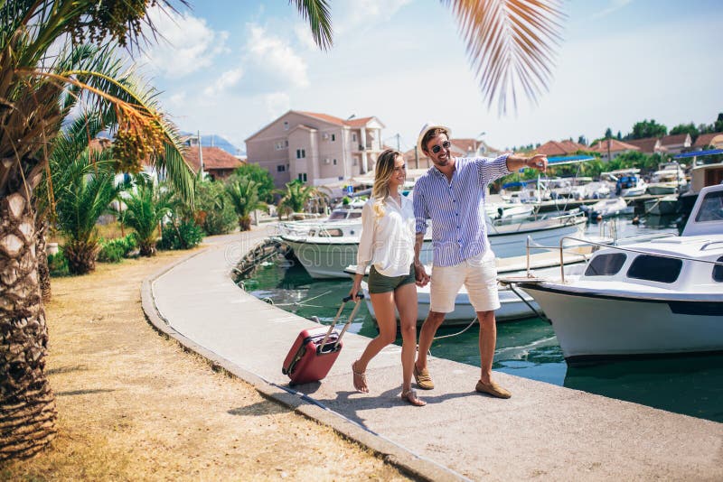 Portrait of two smiling young tourists walking with suitcase. Portrait of two smiling young tourists walking with suitcase