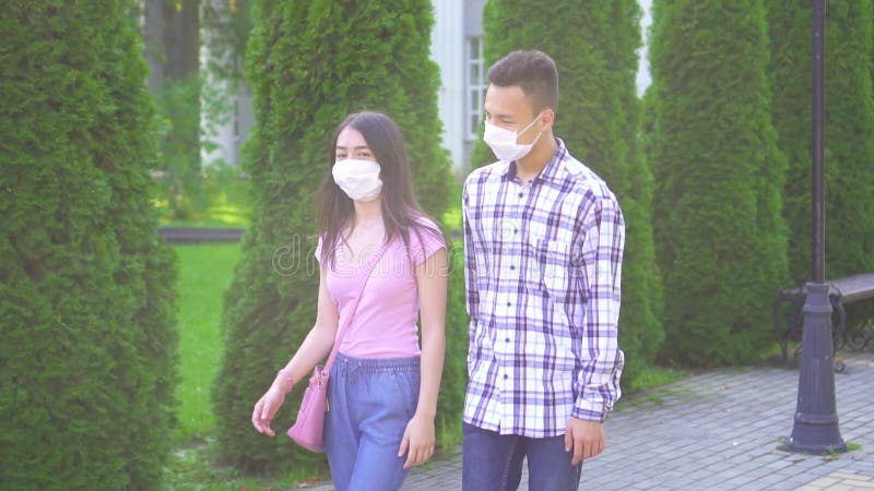 Deux jeunes étudiants asiatiques sur un masque médical, se baladant dans la rue et parlant lentement