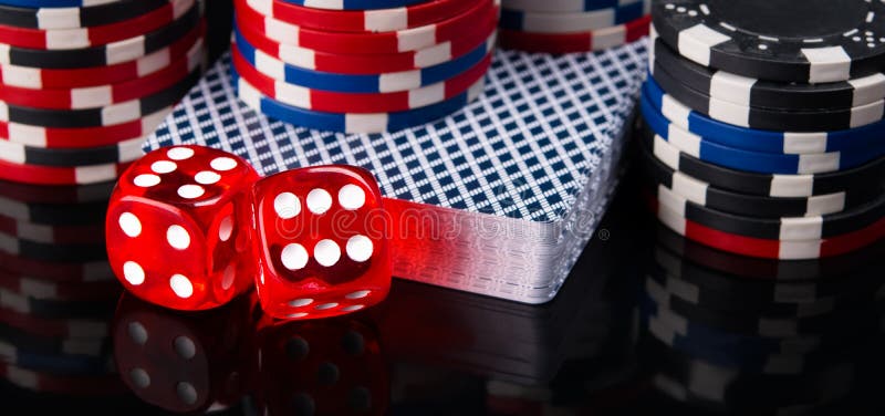 Deux matrices rouges, une plate-forme des cartes et jetons de poker, sur un fond noir photo libre de droits Deux matrices rouges, une plate-forme des cartes et jetons de poker, sur un fond noir photo libre de droits