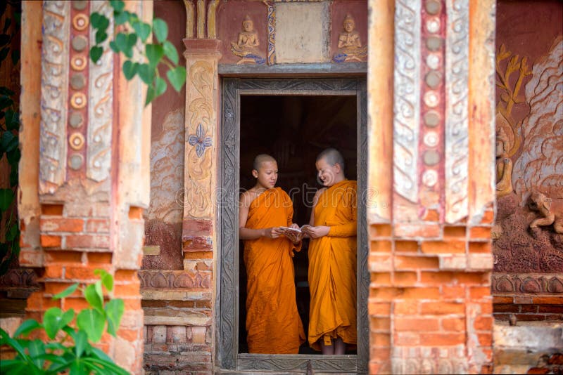 Deux novices tiennent des livres de lecture ensemble dans le temple T photo libre de droits Deux novices tiennent des livres de lecture ensemble dans le temple T photo libre de droits