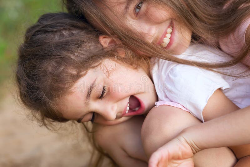 Deux petites filles heureuses riant et étreignant au parc d'été photos libres de droits Deux petites filles heureuses riant et étreignant au parc d'été photos libres de droits