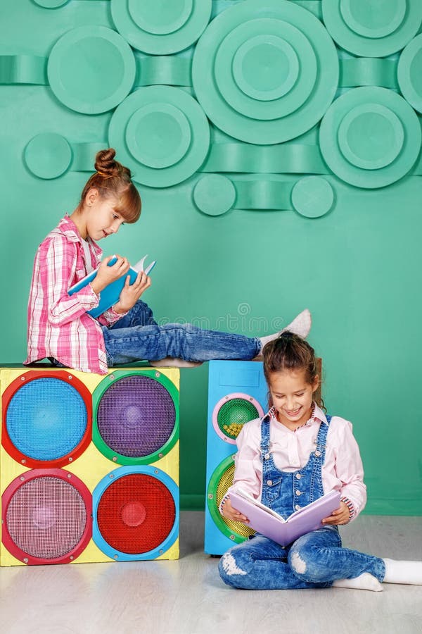 Deux petites filles ont lu des livres dans la chambre Le concept de l'enfance images stock Deux petites filles ont lu des livres dans la chambre Le concept de l'enfance images stock