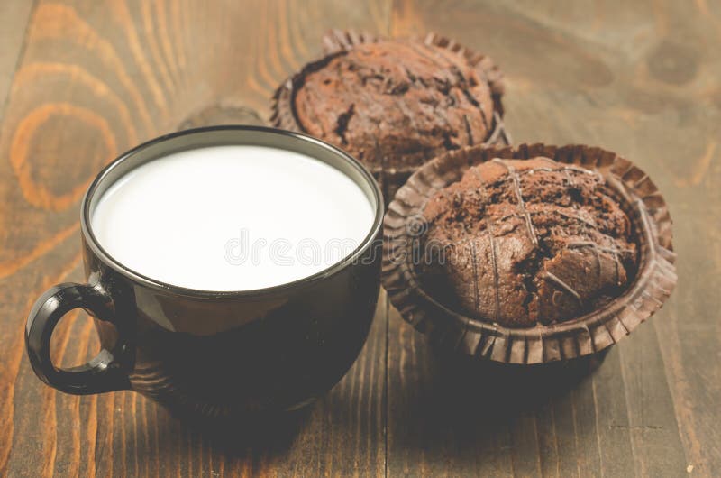 Deux petits pains et laits de chocolat sur un petit pain en bois de fond/deux chocolats dans un plat blanc et une tasse noire ave photos libres de droits Deux petits pains et laits de chocolat sur un petit pain en bois de fond/deux chocolats dans un plat blanc et une tasse noire ave photos libres de droits