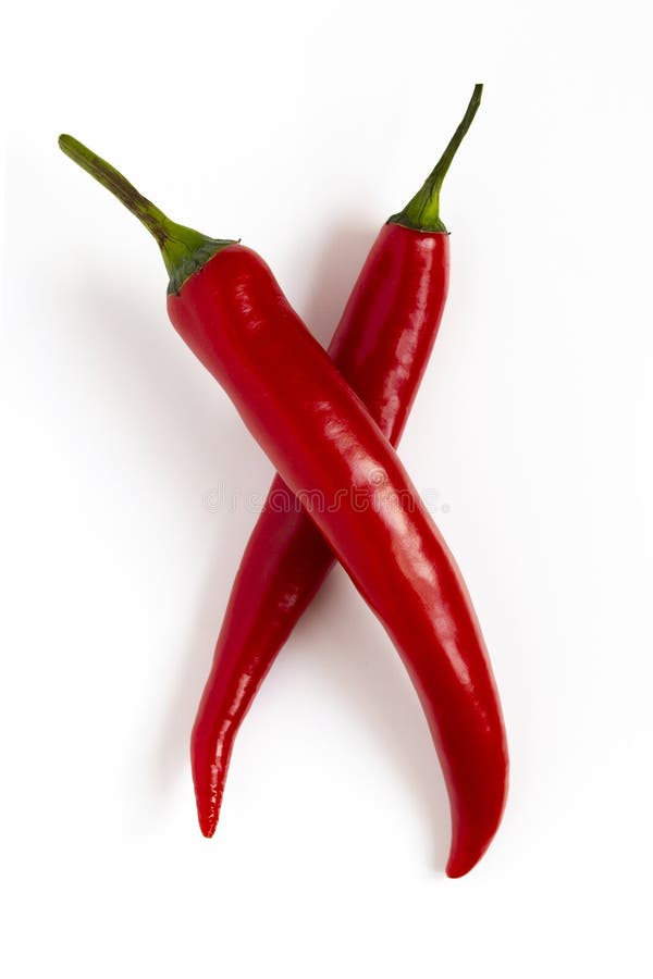 Deux poivrons de piment d'un rouge ardent se trouvent en travers sur un fond blanc Beaux poivrons d'un rouge ardent avec une fusé photo stock Deux poivrons de piment d'un rouge ardent se trouvent en travers sur un fond blanc Beaux poivrons d'un rouge ardent avec une fusé photo stock